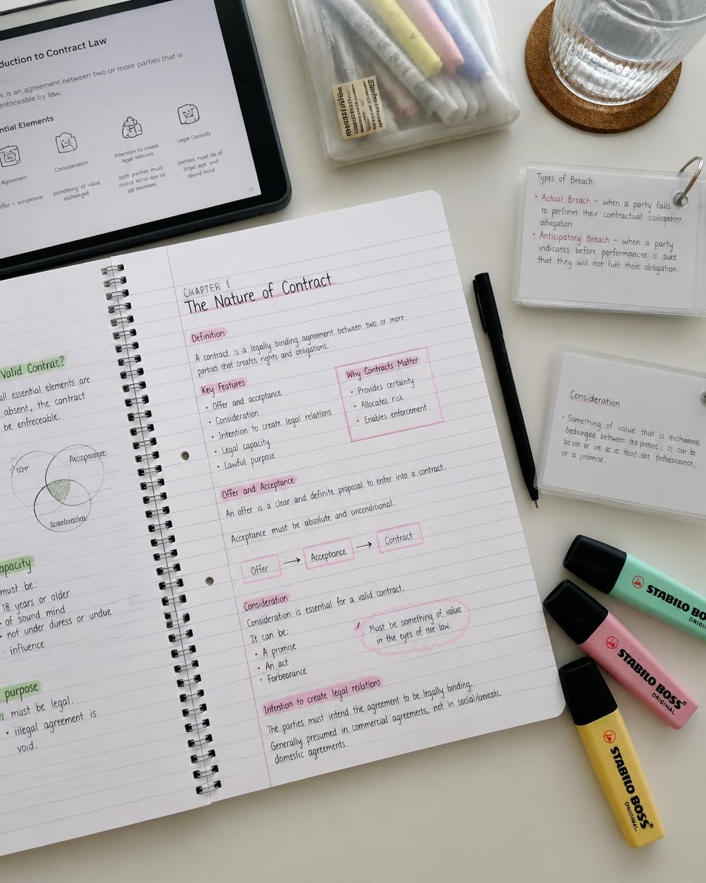 Caderno de estudos do ENEM aberto com marcações coloridas, iPad e flashcards de revisão